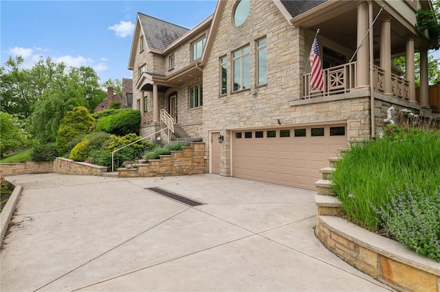 155 Westland Dr, Squirrel Hill, PA 15217 - view of side of property featuring an attached garage, stone siding, driveway, a shingled roof, and a balcony