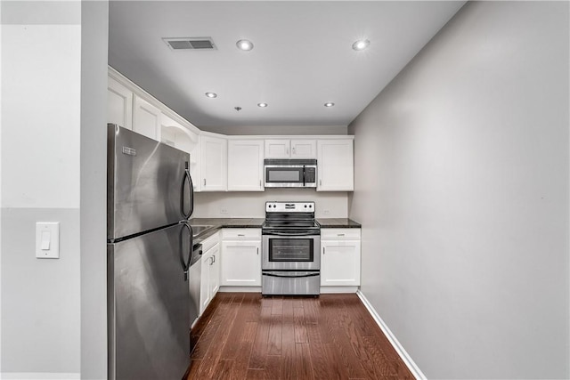 130 S 22nd St Unit 2C, South Side, PA 15203 - kitchen with stainless steel appliances, dark countertops, dark wood-style flooring, white cabinetry, and recessed lighting