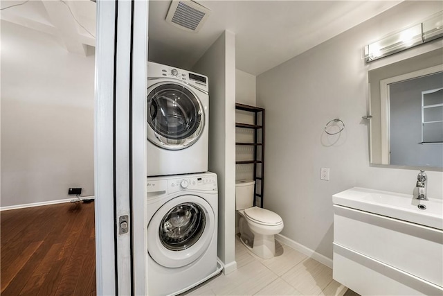 130 S 22nd St Unit 2C, South Side, PA 15203 - bathroom featuring stacked washer and clothes dryer, vanity, toilet, and baseboards