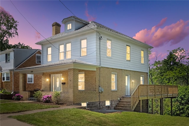 5241 Clarwin Ave, Ross Twp, PA 15229 - back of property at dusk with a lawn, brick siding, a chimney, a deck, and stairs