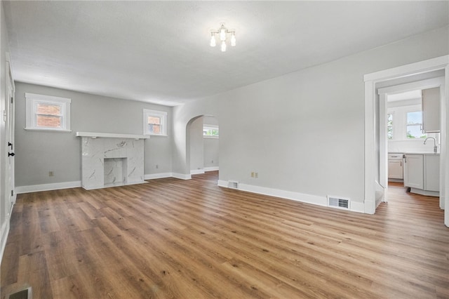 5241 Clarwin Ave, Ross Twp, PA 15229 - unfurnished living room with arched walkways, wood finished floors, healthy amount of natural light, and baseboards