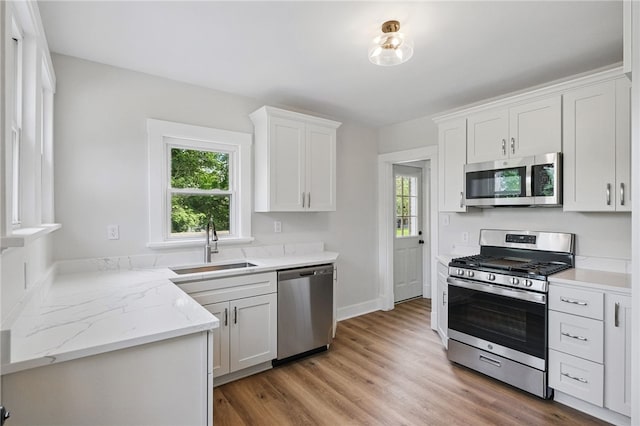 5241 Clarwin Ave, Ross Twp, PA 15229 - kitchen with stainless steel appliances, a sink, white cabinets, light wood finished floors, and baseboards
