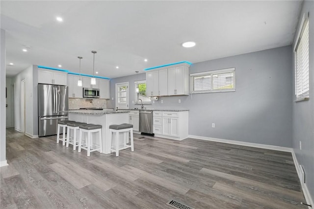259 Allison Ave, Emsworth, PA 15202 - kitchen featuring stainless steel appliances, baseboards, a center island, a breakfast bar, and white cabinetry