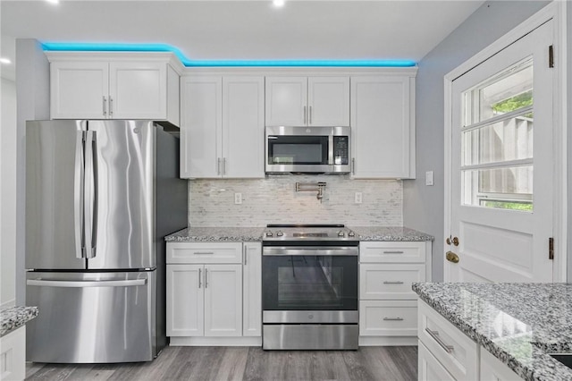 259 Allison Ave, Emsworth, PA 15202 - kitchen featuring stainless steel appliances, wood finished floors, backsplash, white cabinets, and light stone counters