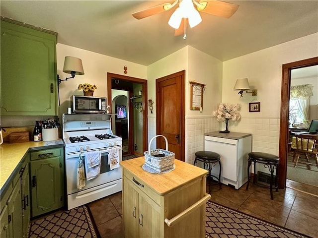109 Center Dr, East Franklin Twp, PA 16210 - kitchen featuring white range with gas stovetop, stainless steel microwave, green cabinets, light countertops, and a ceiling fan