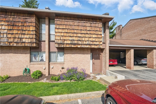 14 Forest Green Dr, Moon/Crescent Twp, PA 15108 - view of side of property featuring brick siding, covered parking, and mansard roof