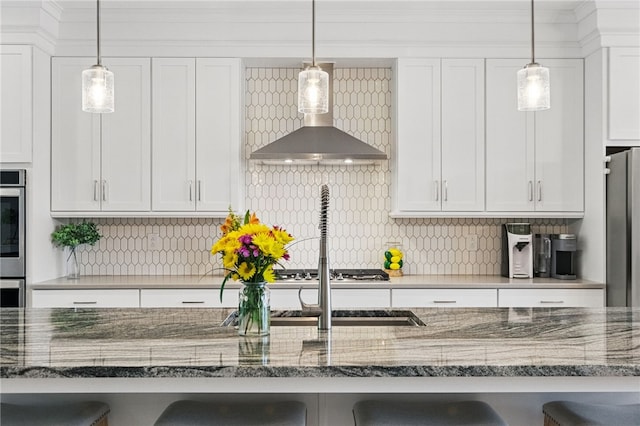 349 Azalea Dr, Peters Twp, PA 15367 - kitchen featuring wall chimney exhaust hood, a breakfast bar area, white cabinets, stainless steel appliances, and decorative backsplash