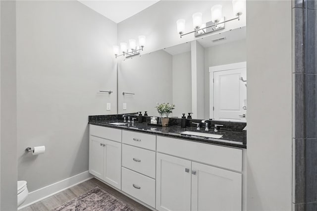 349 Azalea Dr, Peters Twp, PA 15367 - bathroom featuring double vanity, wood finished floors, toilet, and baseboards