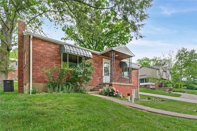 1332 Rte 519, North Strabane, PA 15330 - view of front of house with a front lawn, brick siding, a chimney, and central AC unit