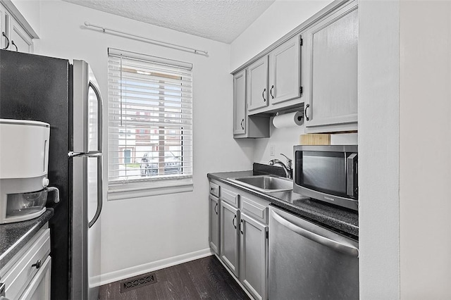 121 Woodhaven Dr, Seven Fields Boro, PA 16046 - kitchen featuring stainless steel appliances, dark countertops, a sink, plenty of natural light, and a textured ceiling