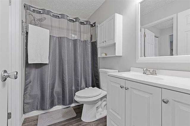 121 Woodhaven Dr, Seven Fields Boro, PA 16046 - bathroom featuring a textured ceiling, vanity, toilet, wood finished floors, and shower / bath combination with curtain
