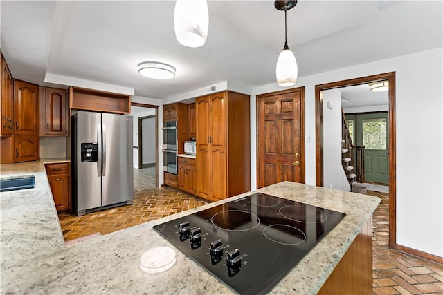 4117 Kellington Ct, Murrysville, PA 15668 - kitchen featuring appliances with stainless steel finishes, brick floors, hanging light fixtures, and brown cabinets