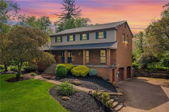 4117 Kellington Ct, Murrysville, PA 15668 - view of front of home featuring decorative driveway, a porch, brick siding, an attached garage, and a front yard