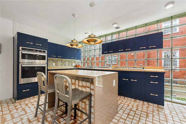 2219 Beechwood Blvd, Squirrel Hill, PA 15217 - kitchen with blue cabinets, a center island, backsplash, double oven, and a kitchen breakfast bar