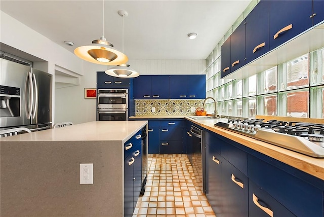 2219 Beechwood Blvd, Squirrel Hill, PA 15217 - kitchen with blue cabinetry, appliances with stainless steel finishes, a sink, tasteful backsplash, and hanging light fixtures