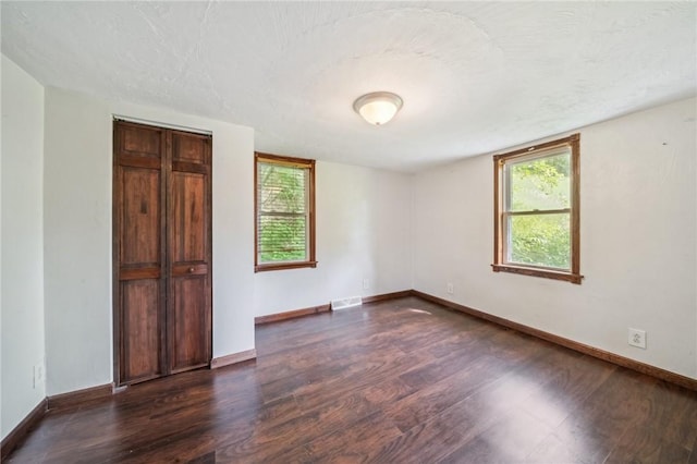914 Western Ave, Jeannette, PA 15644 - unfurnished bedroom with dark wood-style floors, baseboards, and a textured ceiling