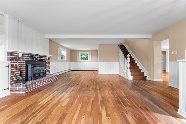 271 Harbison Rd, Buffalo Twp But, PA 16055 - unfurnished living room with wood-type flooring, stairs, a wainscoted wall, and a wood stove