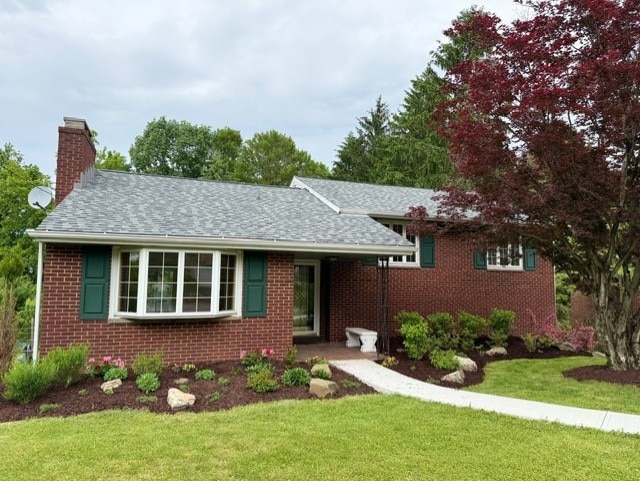 2612 Saybrook Dr, Churchill Boro, PA 15235 - view of front facade with brick siding, a front yard, and a chimney