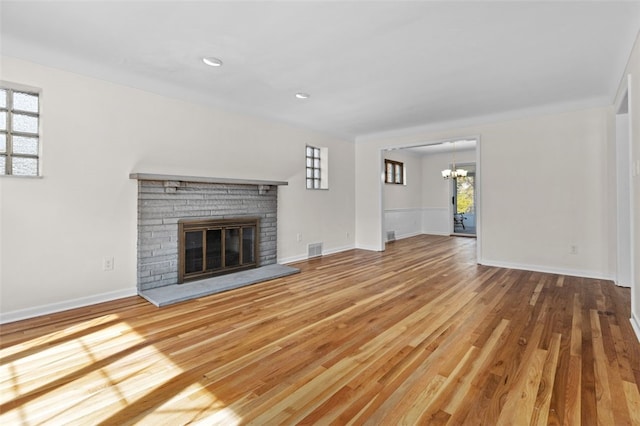 2612 Saybrook Dr, Churchill Boro, PA 15235 - unfurnished living room featuring a chandelier, a brick fireplace, wood finished floors, baseboards, and recessed lighting