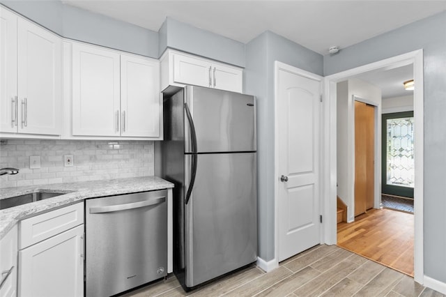 2612 Saybrook Dr, Churchill Boro, PA 15235 - kitchen featuring appliances with stainless steel finishes, light wood-style floors, white cabinetry, decorative backsplash, and a sink