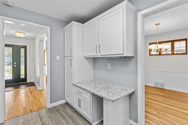 2612 Saybrook Dr, Churchill Boro, PA 15235 - kitchen with wood finished floors, white cabinets, baseboards, and a chandelier