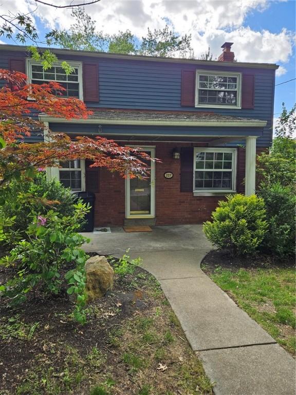 227 Ridge Ave, Forest Hills Boro, PA 15221 - view of front facade featuring a chimney, brick siding, and covered porch