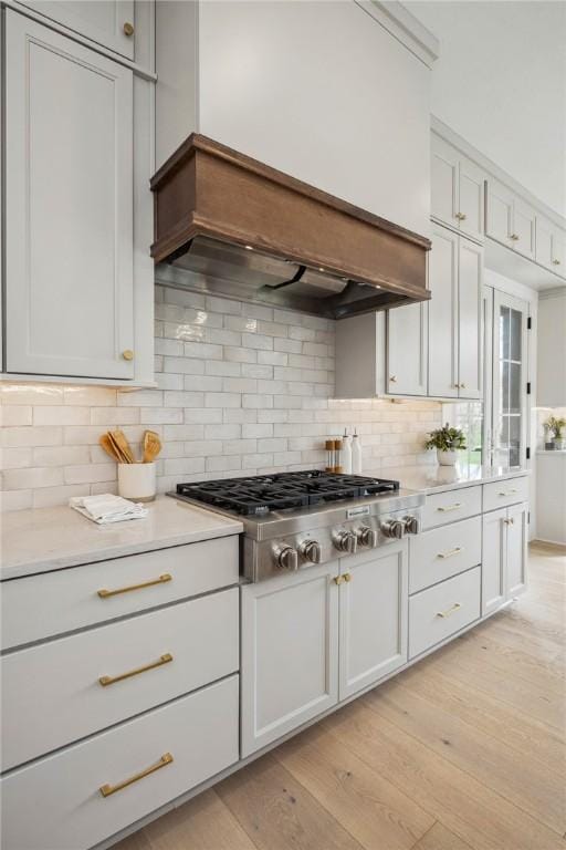 205 Rothaar Ct, Peters Twp, PA 15367 - kitchen featuring stainless steel gas cooktop, light countertops, backsplash, white cabinets, and light wood-style floors