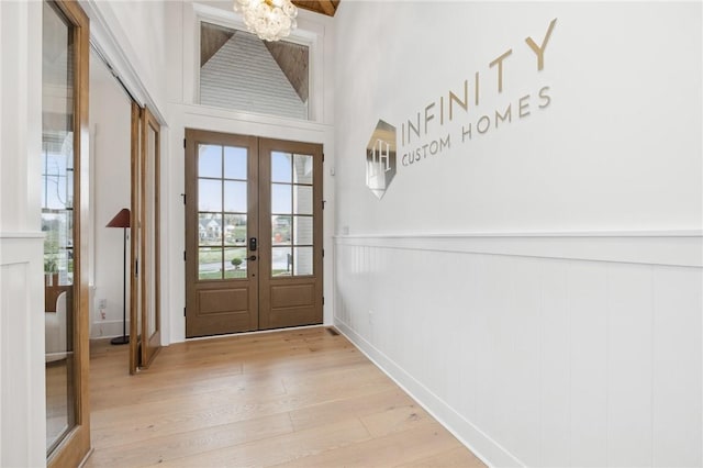 205 Rothaar Ct, Peters Twp, PA 15367 - entryway featuring french doors, a chandelier, light wood-style floors, and a wainscoted wall
