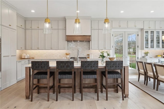 205 Rothaar Ct, Peters Twp, PA 15367 - kitchen featuring backsplash, light countertops, light wood-style floors, a kitchen bar, and recessed lighting