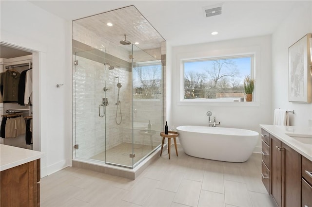205 Rothaar Ct, Peters Twp, PA 15367 - bathroom with vanity, a shower stall, a soaking tub, a spacious closet, and baseboards