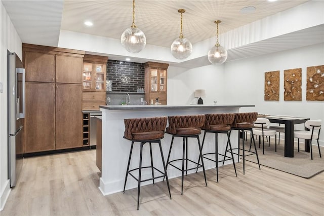 205 Rothaar Ct, Peters Twp, PA 15367 - kitchen with stainless steel fridge, light wood finished floors, a kitchen breakfast bar, brown cabinetry, and pendant lighting