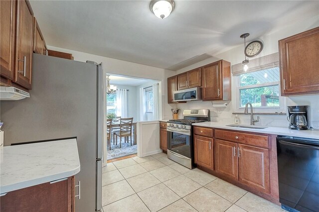 106 Richard Dr, Ross Twp, PA 15237 - kitchen with appliances with stainless steel finishes, a sink, light countertops, light tile patterned flooring, and a chandelier