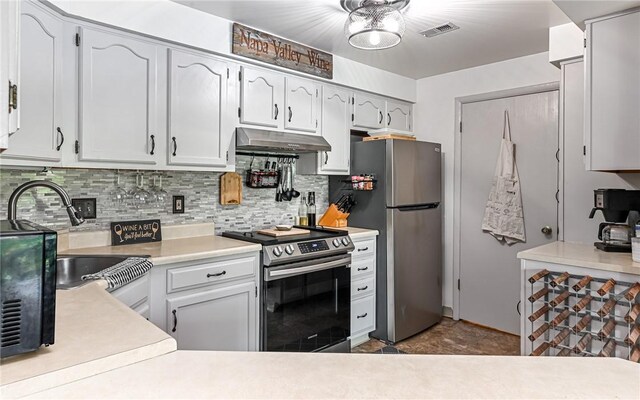 1556 Fairmont St, Wilkinsburg, PA 15221 - kitchen with stainless steel appliances, under cabinet range hood, a sink, light countertops, and tasteful backsplash