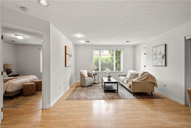 100 Denniston St Unit 211, Shadyside, PA 15206 - living room with light wood-style floors, a textured ceiling, and baseboards