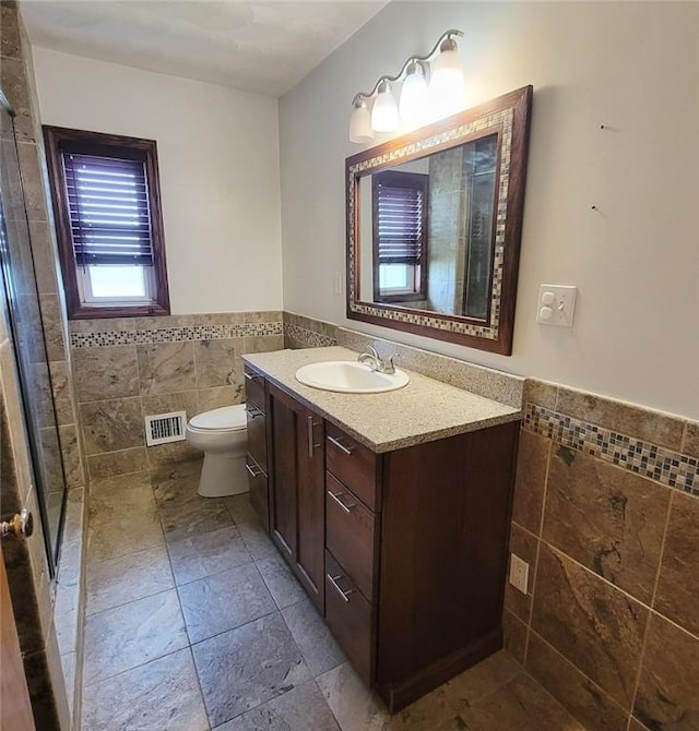2216 Manor Dr, Manor Twp, PA 16226 - full bath featuring tile walls, a wainscoted wall, vanity, a stall shower, and toilet