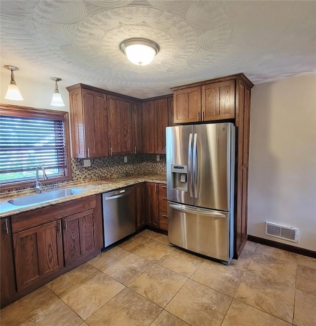 2216 Manor Dr, Manor Twp, PA 16226 - kitchen featuring appliances with stainless steel finishes, a sink, tasteful backsplash, baseboards, and light stone countertops