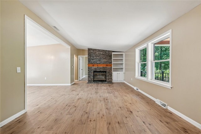 763 W Mountainview Rd, Bullskin Twp, PA 15610 - unfurnished living room featuring light wood-style floors, a stone fireplace, baseboards, and built in shelves