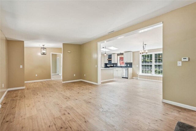 763 W Mountainview Rd, Bullskin Twp, PA 15610 - unfurnished living room with a chandelier, light wood finished floors, and baseboards