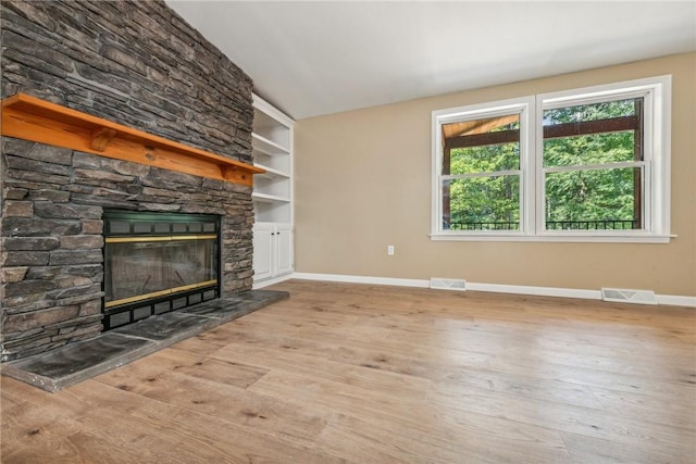 763 W Mountainview Rd, Bullskin Twp, PA 15610 - unfurnished living room with a stone fireplace, baseboards, wood finished floors, and lofted ceiling