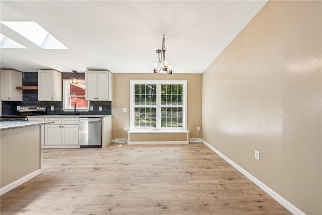 763 W Mountainview Rd, Bullskin Twp, PA 15610 - kitchen with appliances with stainless steel finishes, backsplash, light wood-style floors, a chandelier, and baseboards