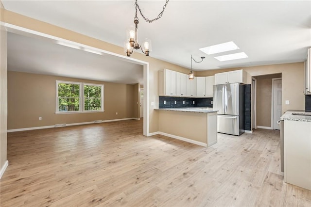 763 W Mountainview Rd, Bullskin Twp, PA 15610 - kitchen featuring a skylight, freestanding refrigerator, open floor plan, backsplash, and a chandelier
