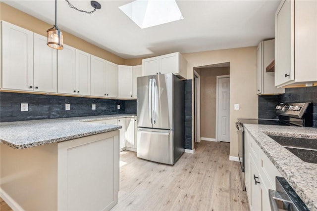763 W Mountainview Rd, Bullskin Twp, PA 15610 - kitchen with appliances with stainless steel finishes, backsplash, a skylight, baseboards, and light wood-style flooring