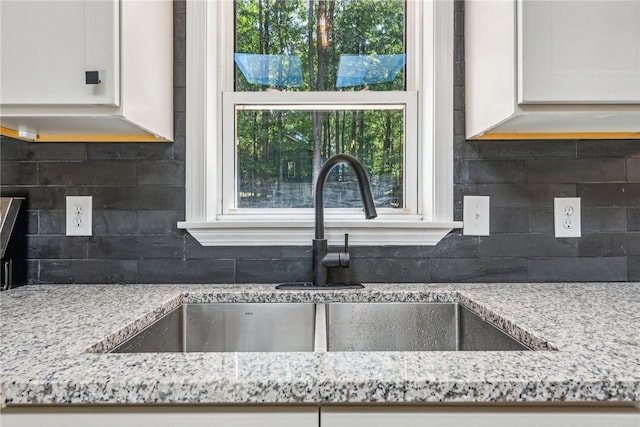 763 W Mountainview Rd, Bullskin Twp, PA 15610 - kitchen featuring a sink, backsplash, light stone counters, and white cabinetry