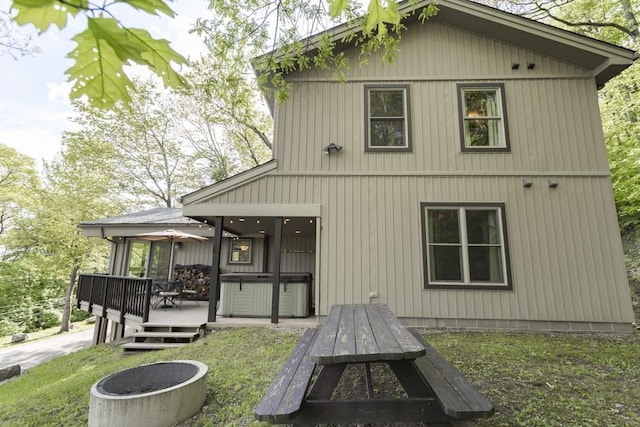 2226 County Line Rd, Donegal Wml, PA 15622 - rear view of house featuring a wooden deck, a hot tub, an outdoor fire pit, and a yard