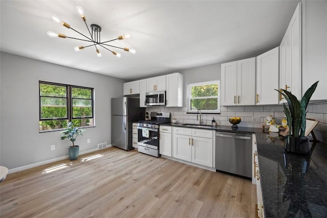 220 Cortina Way, Overbrook, PA 15234 - kitchen with stainless steel appliances, a sink, a chandelier, light wood-style floors, and backsplash