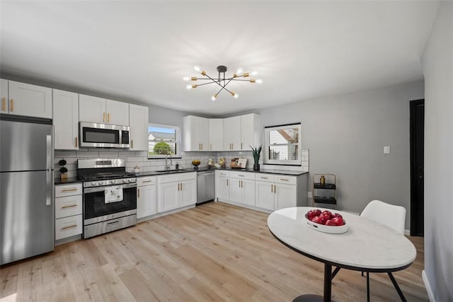 220 Cortina Way, Overbrook, PA 15234 - kitchen featuring stainless steel appliances, a sink, healthy amount of natural light, and backsplash