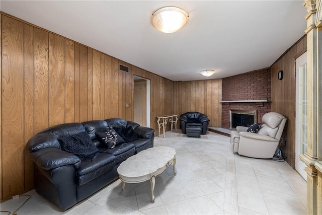 110 Ardennes Ct, Trafford, PA 15085 - living room featuring wooden walls, a brick fireplace, and light tile patterned flooring
