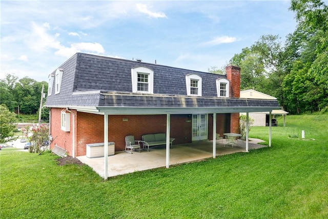 110 Ardennes Ct, Trafford, PA 15085 - back of property featuring mansard roof, roof with shingles, brick siding, a yard, and a patio area