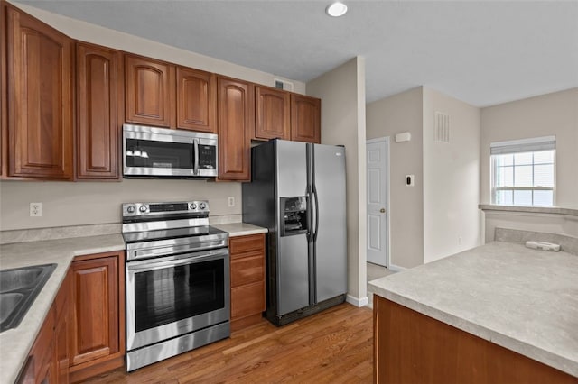 190 Southern Valley Ct, Adams Twp, PA 16046 - kitchen featuring stainless steel appliances, light wood finished floors, brown cabinetry, and light countertops