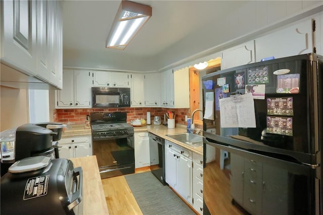 304 Petain St, Ellwood City Law, PA 16117 - kitchen featuring black appliances, a sink, light countertops, and white cabinetry